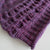 CLose up of a purple hand knitted hat showing the gathered detail