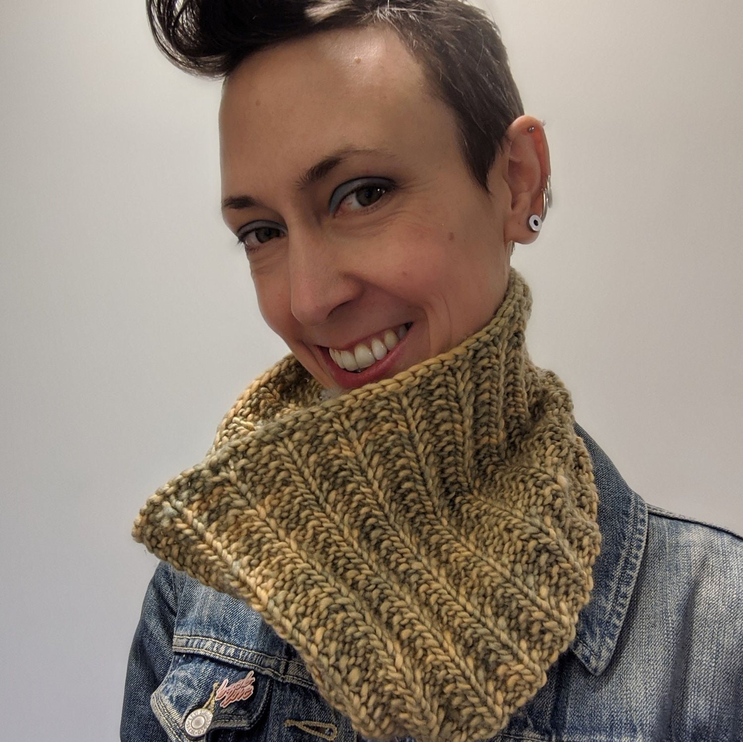 Person smiling wearing a hand knitted bulky weight cowl