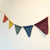 5 rainbow coloured bunting hanging against a wall