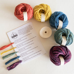 5 mini cakes of yarn, rolled up cotton twill and a yarn tasting card