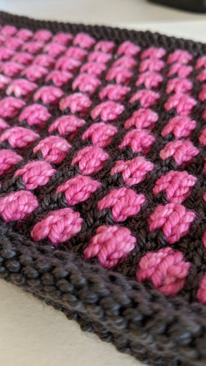 Close up of 3D knitted cowl in pink and grey